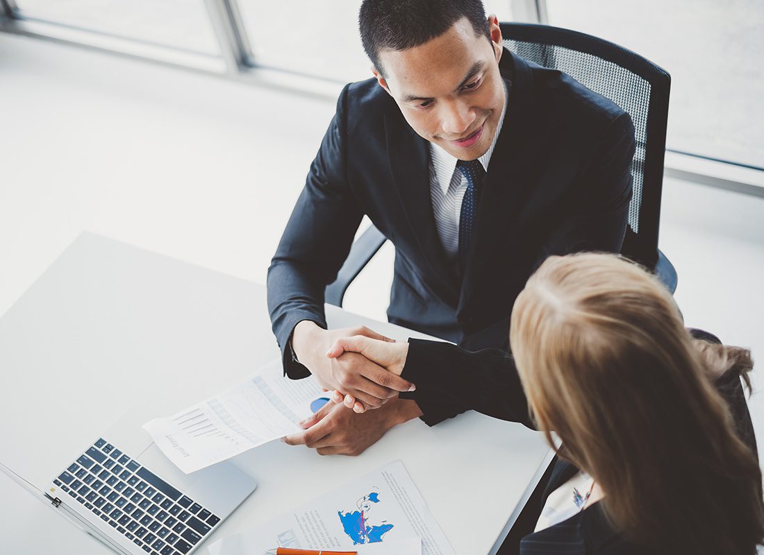 About Our Agency - Overhead View of Two Business Professionals Sitting Together at an Office